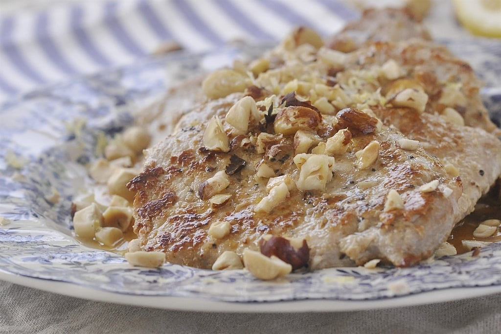 lemon pork chops topped with chopped hazelnuts