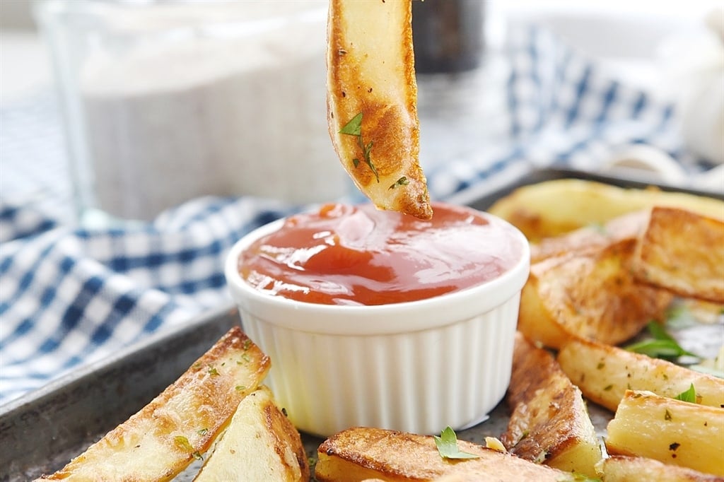 dipping a garlic frie in ketchup