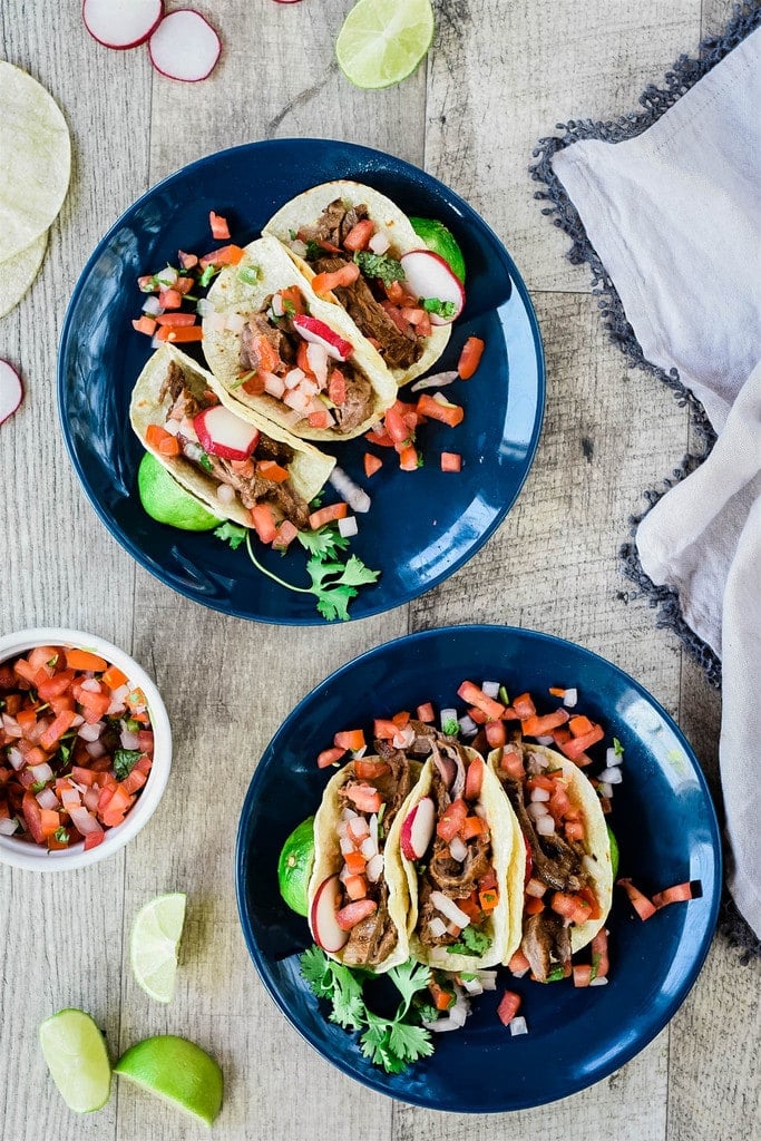 three steak tacos on a blue plate