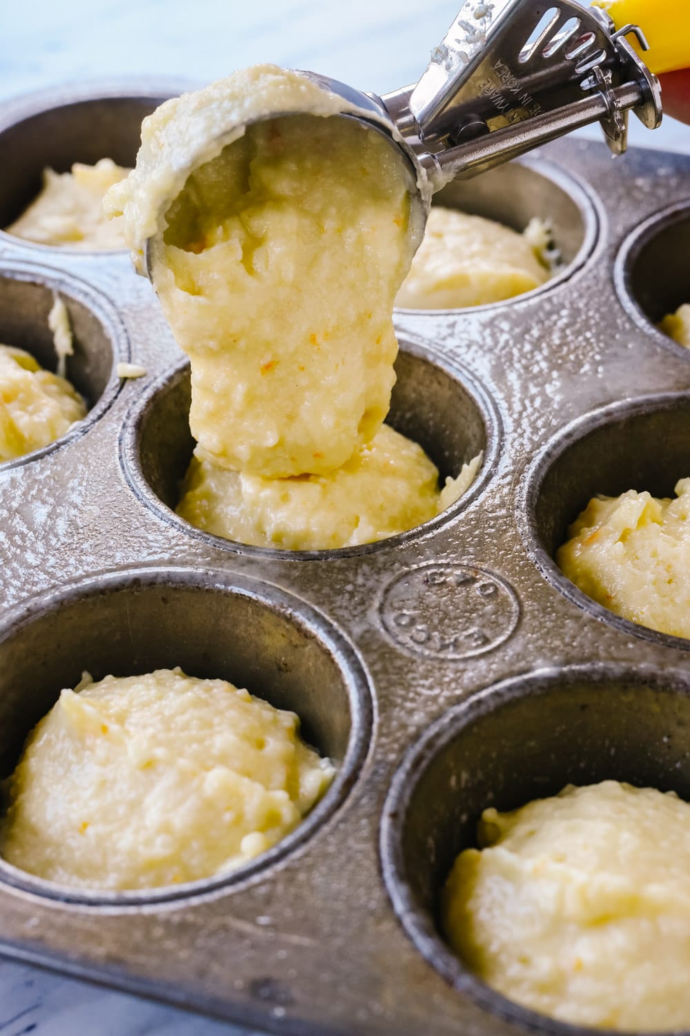 Scooping Marmalade Muffin Batter into muffin tins