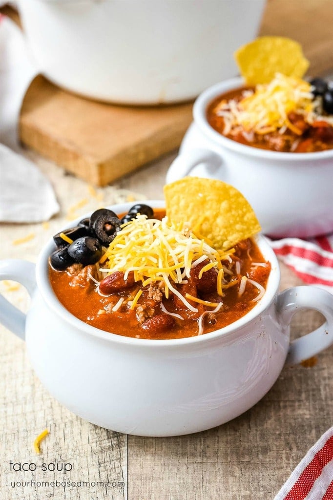 Taco Soup in a bowl with cheese black olives and tortilla chips