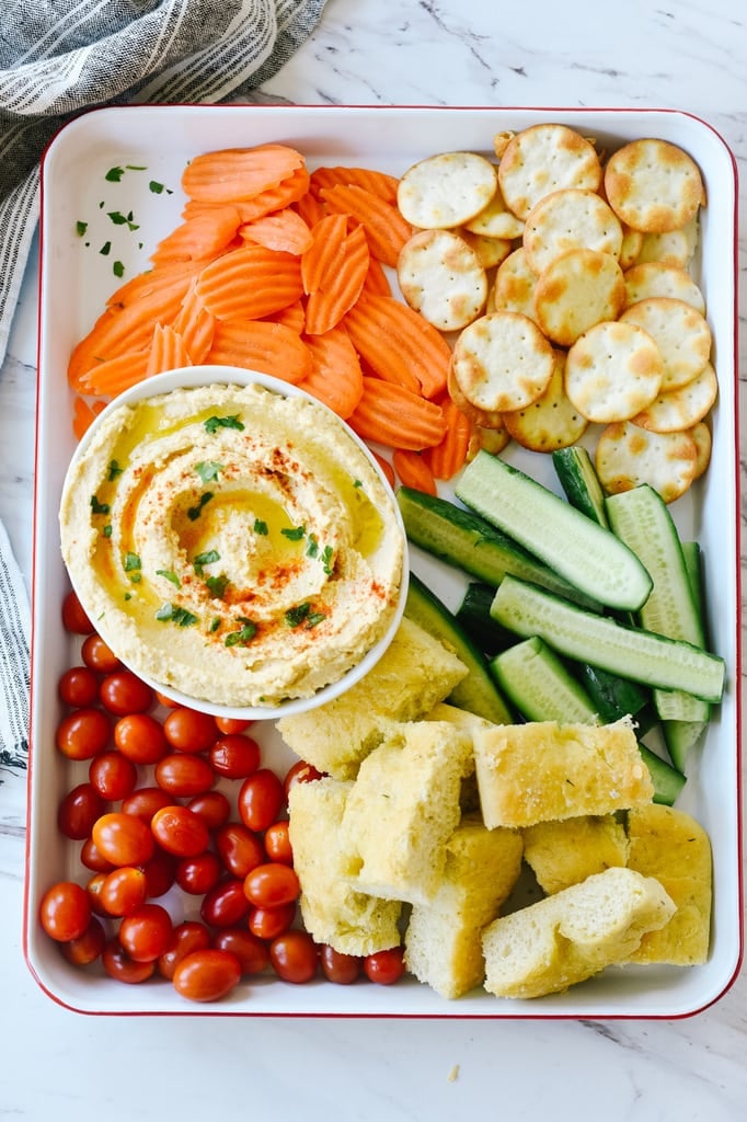 tray of hummus bread veggies and chips