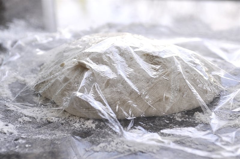 No Knead Artisan Bread Dough Rising under plastic wrap