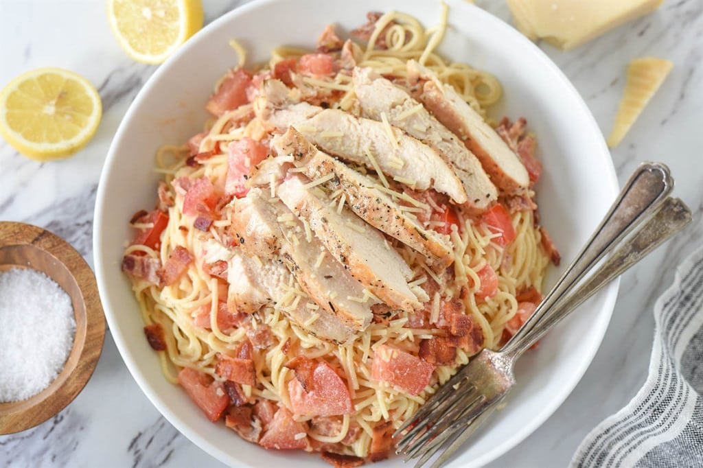 lemon pasta topped with lemon chicken in a serving dish