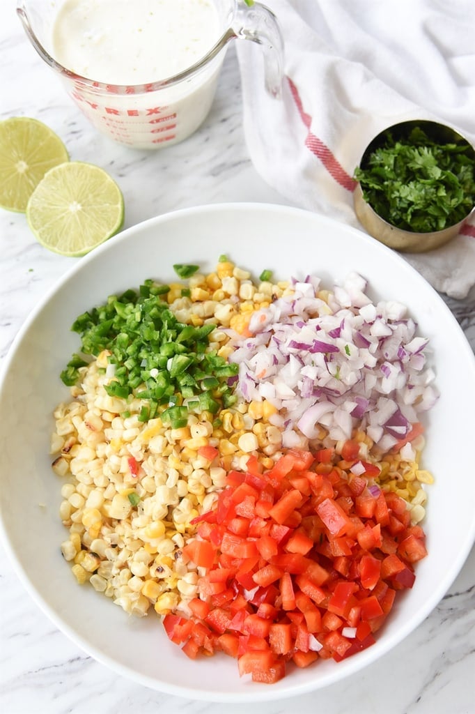 bowl of raosted corn onions tomato jalepeno ingredients for corn salad