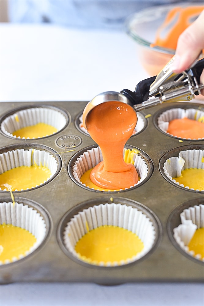 scoooping orange cake batter