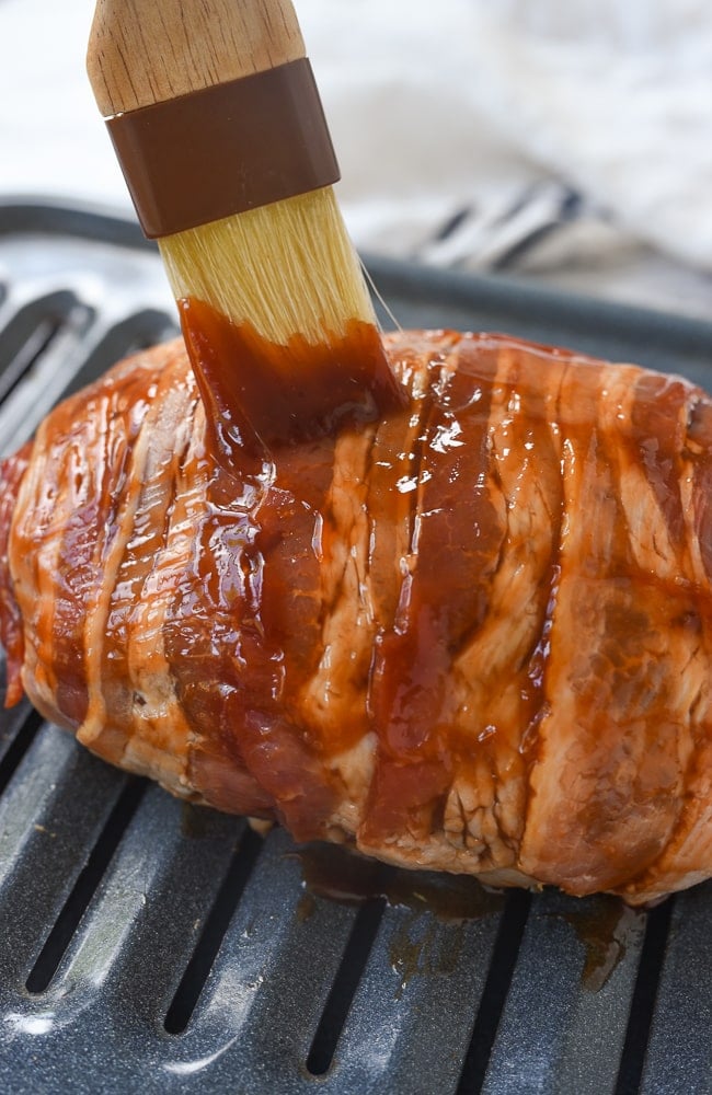 brushing ketchup gravy of bacon wrapped meatloaf