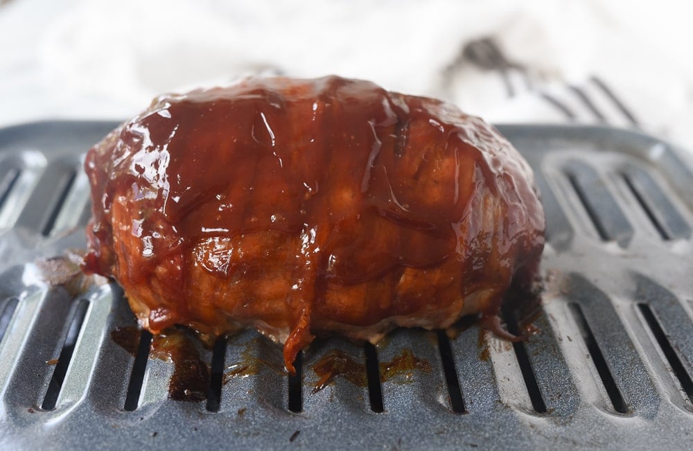bacon wrapped meatloaf brushed with ketchup