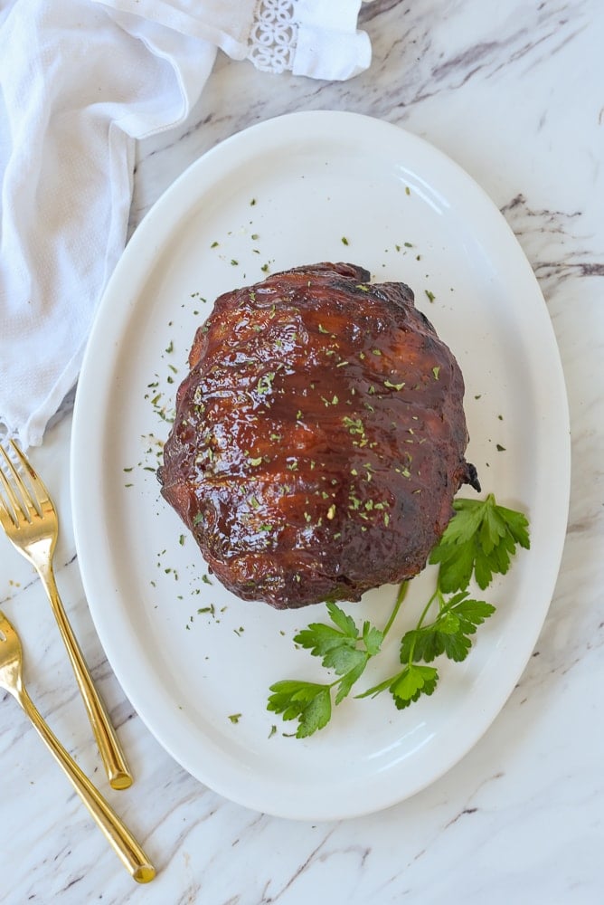 bacon wrapped meatloaf on a white plate