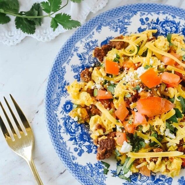 chorizo and eggs on blue and white plate