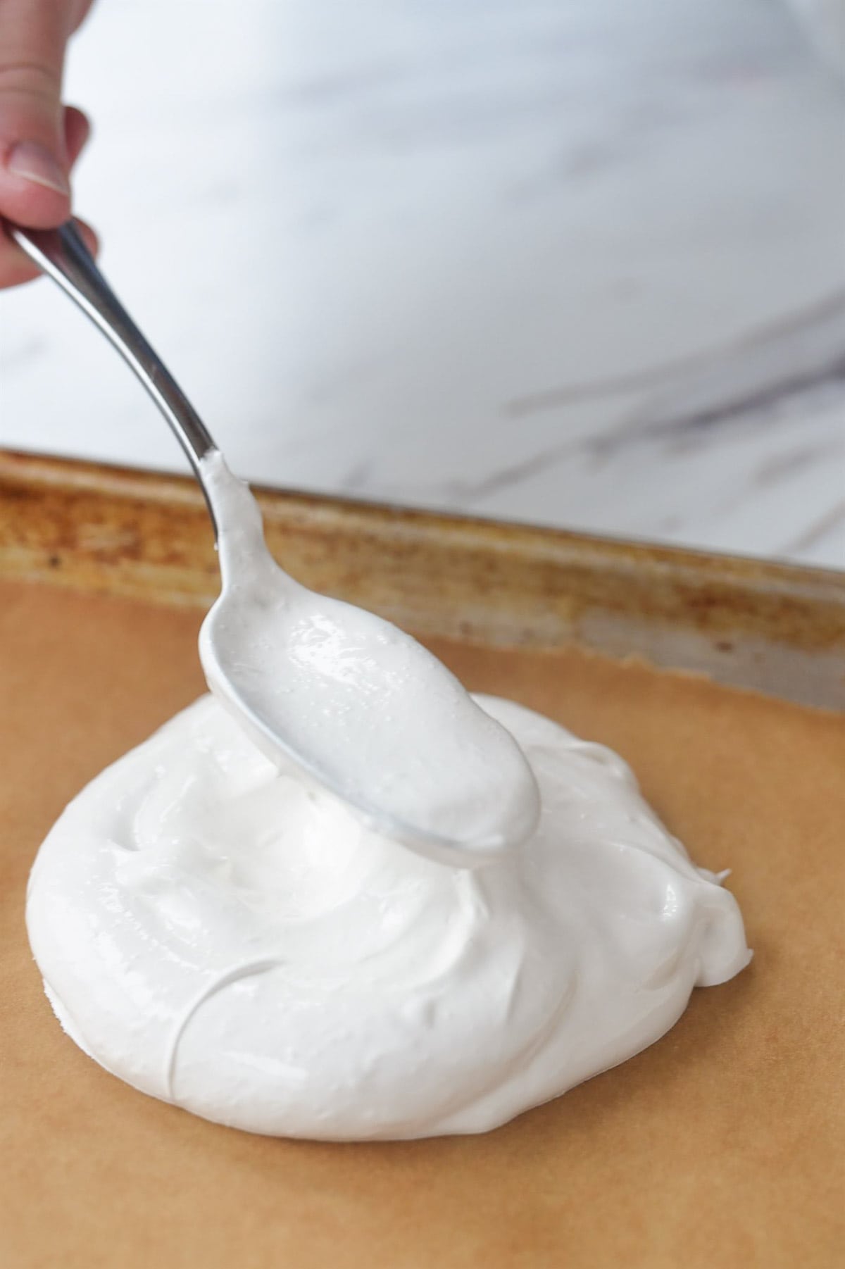 spooning meringue onto parchment paper