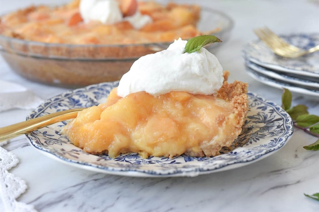 slice of fresh peach pie on a plate