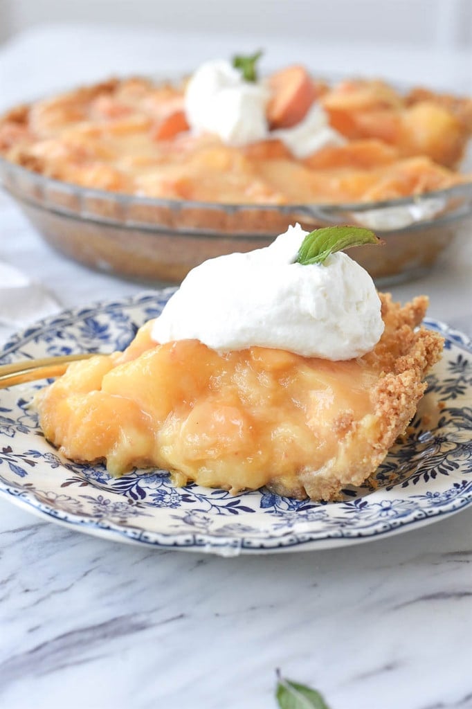 slice of fresh peach pie topped with whipped cream