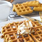 Pumpkin Waffles with whipped cream and syrup on top