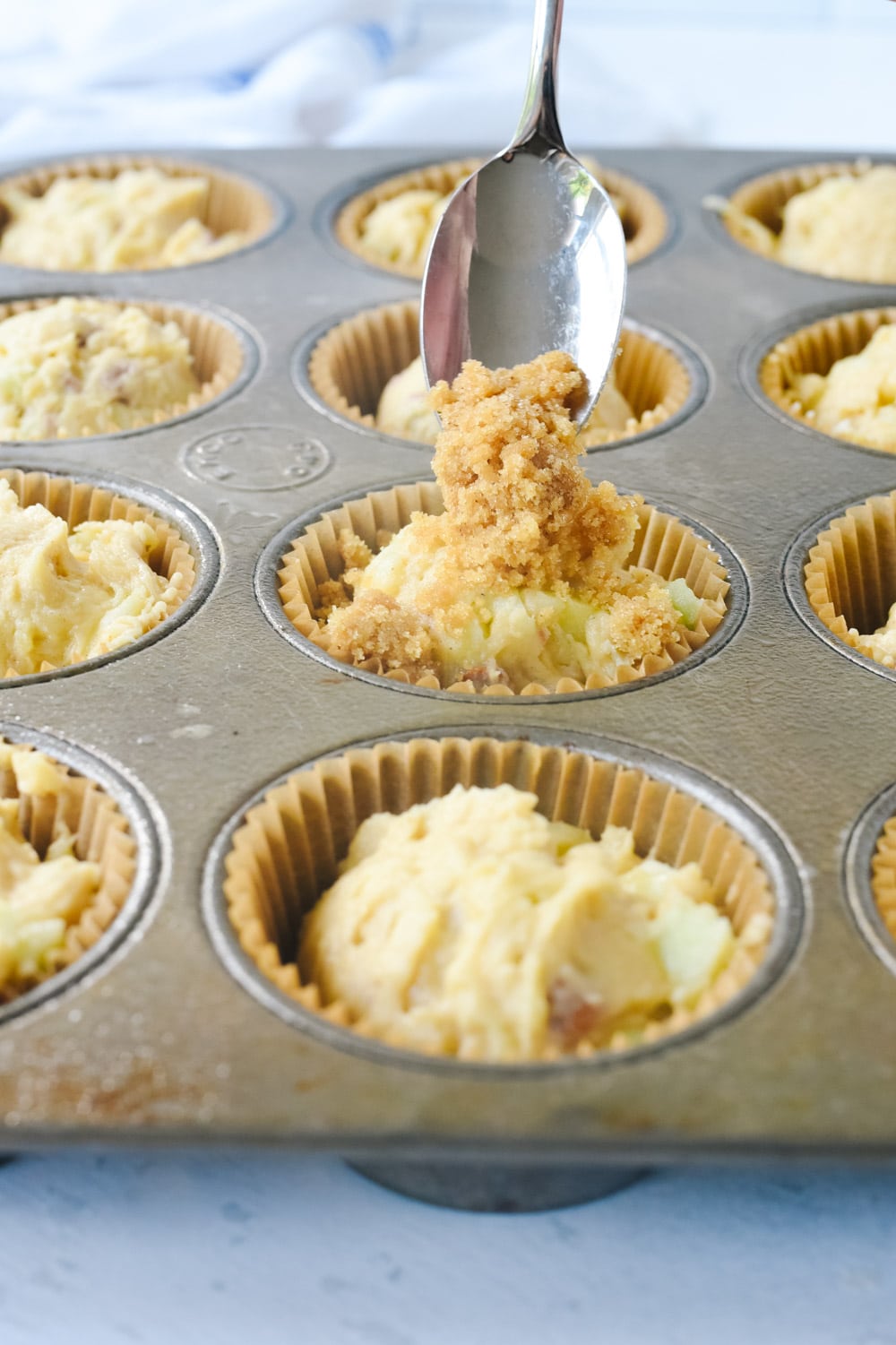 adding streusel topping to muffins