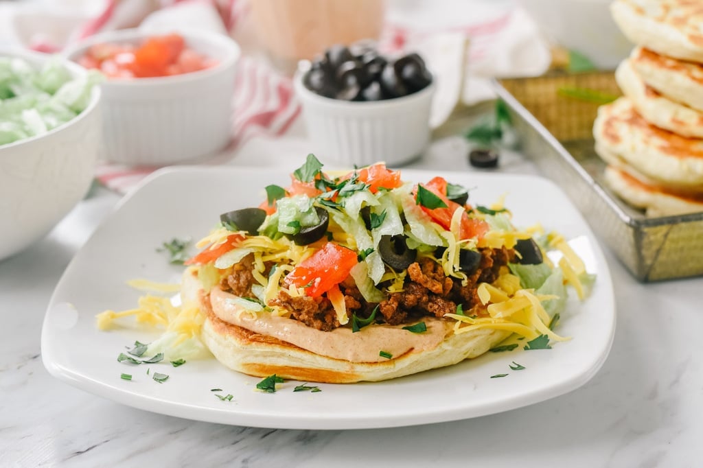 Taco Flatbread with tomatoes lettuce cheese and black olives