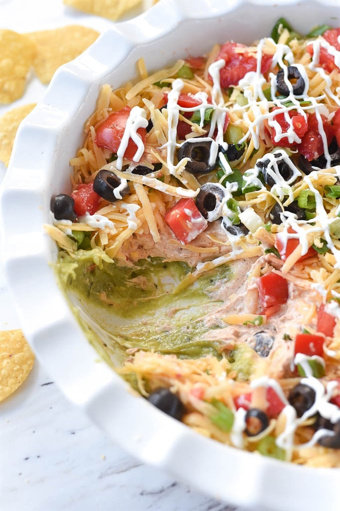 Seven Layer Dip drizzled with sour cream