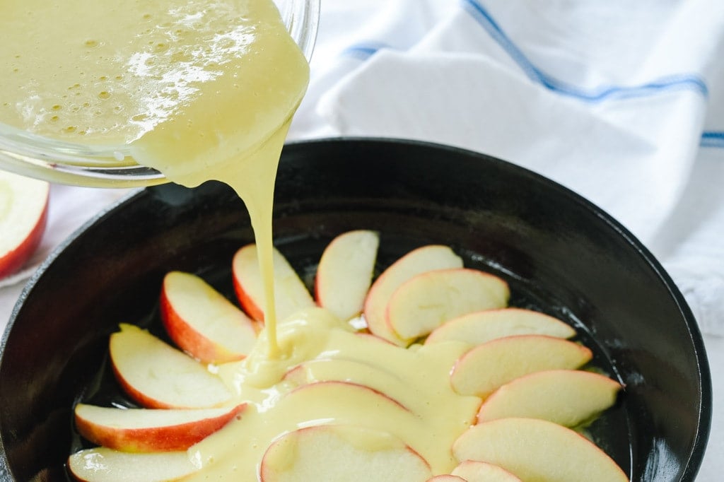 pouring egg mixture over dutch baby