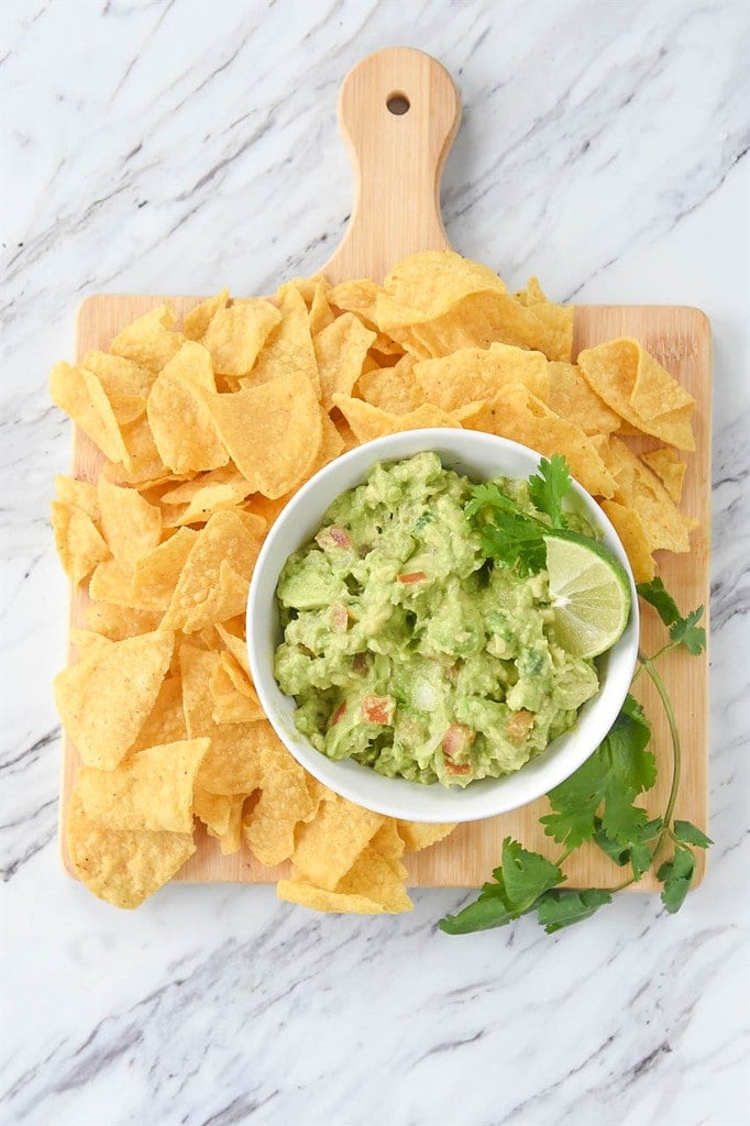 Guacamole and chips on a board