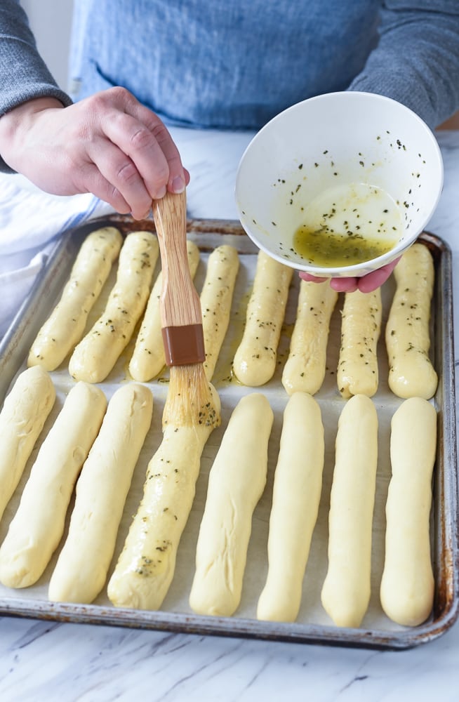 brushing butter on breadsticks