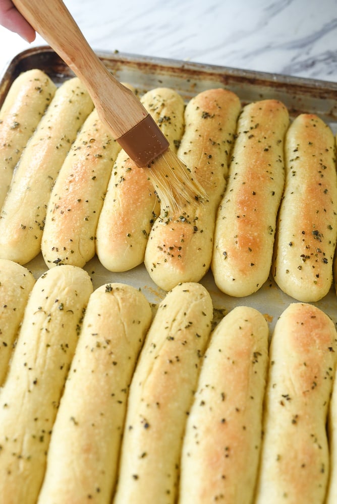 brushing baked breasticks with butter