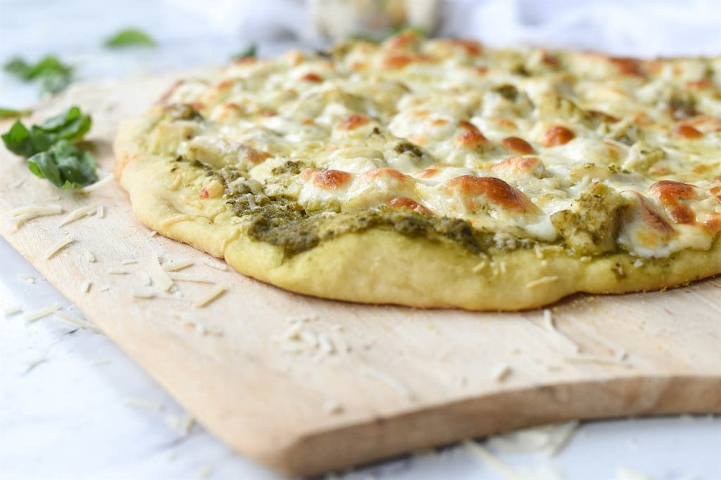 chicken pesto pizza on a pizza peel