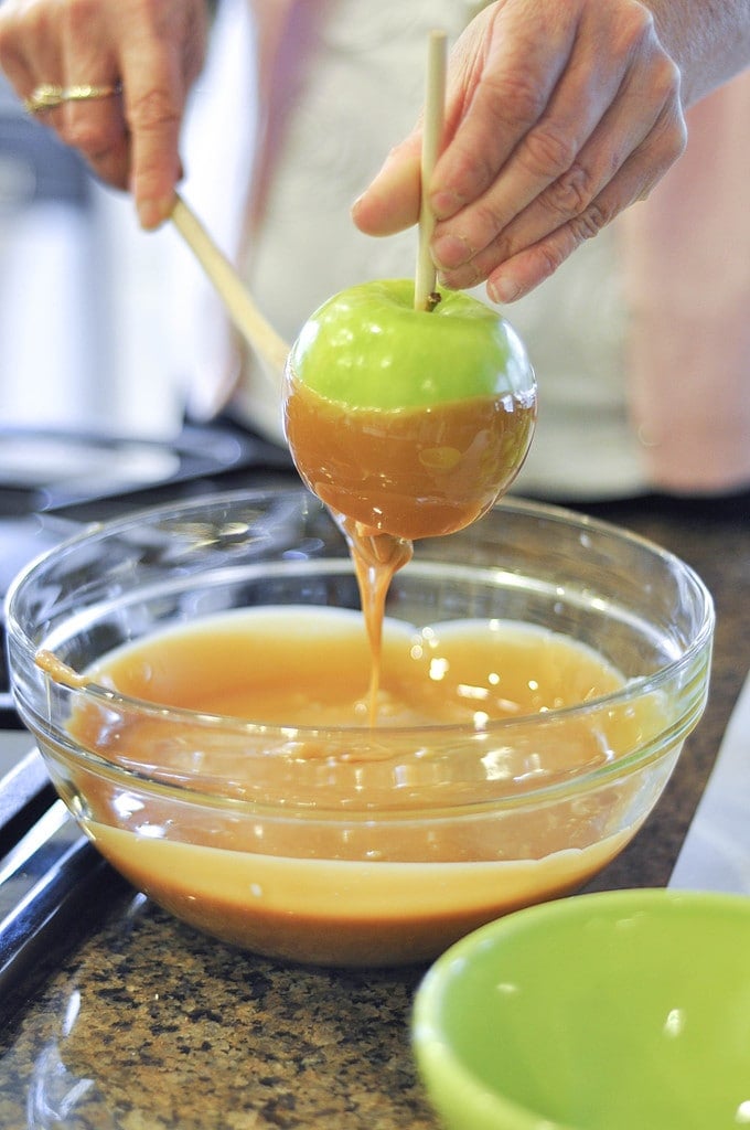 dipping a granny smith apple in caramel