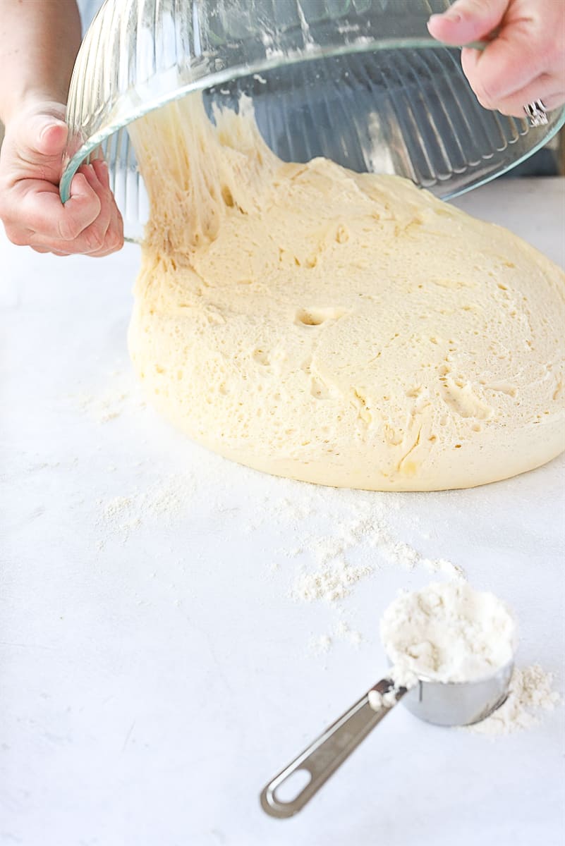 pouring dough out of bowl onto counter