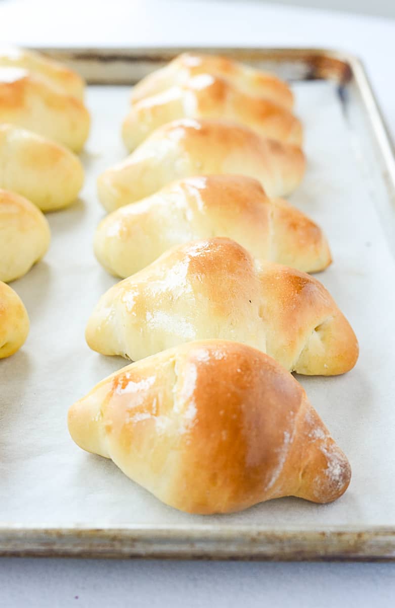 rolls prushed with butter on baking sheet