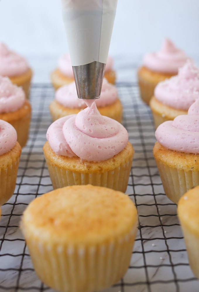 frosting a pink lemonade cupcake