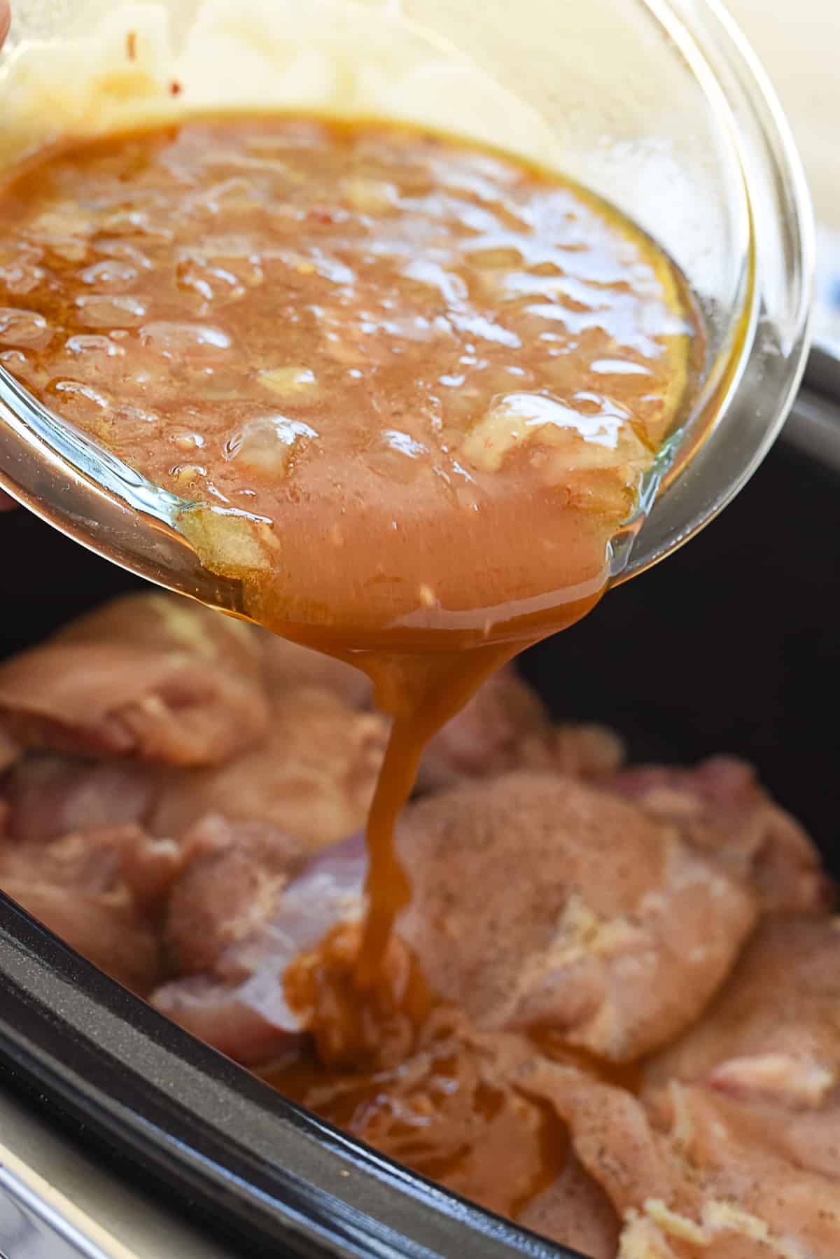 pouring sauce over chicken