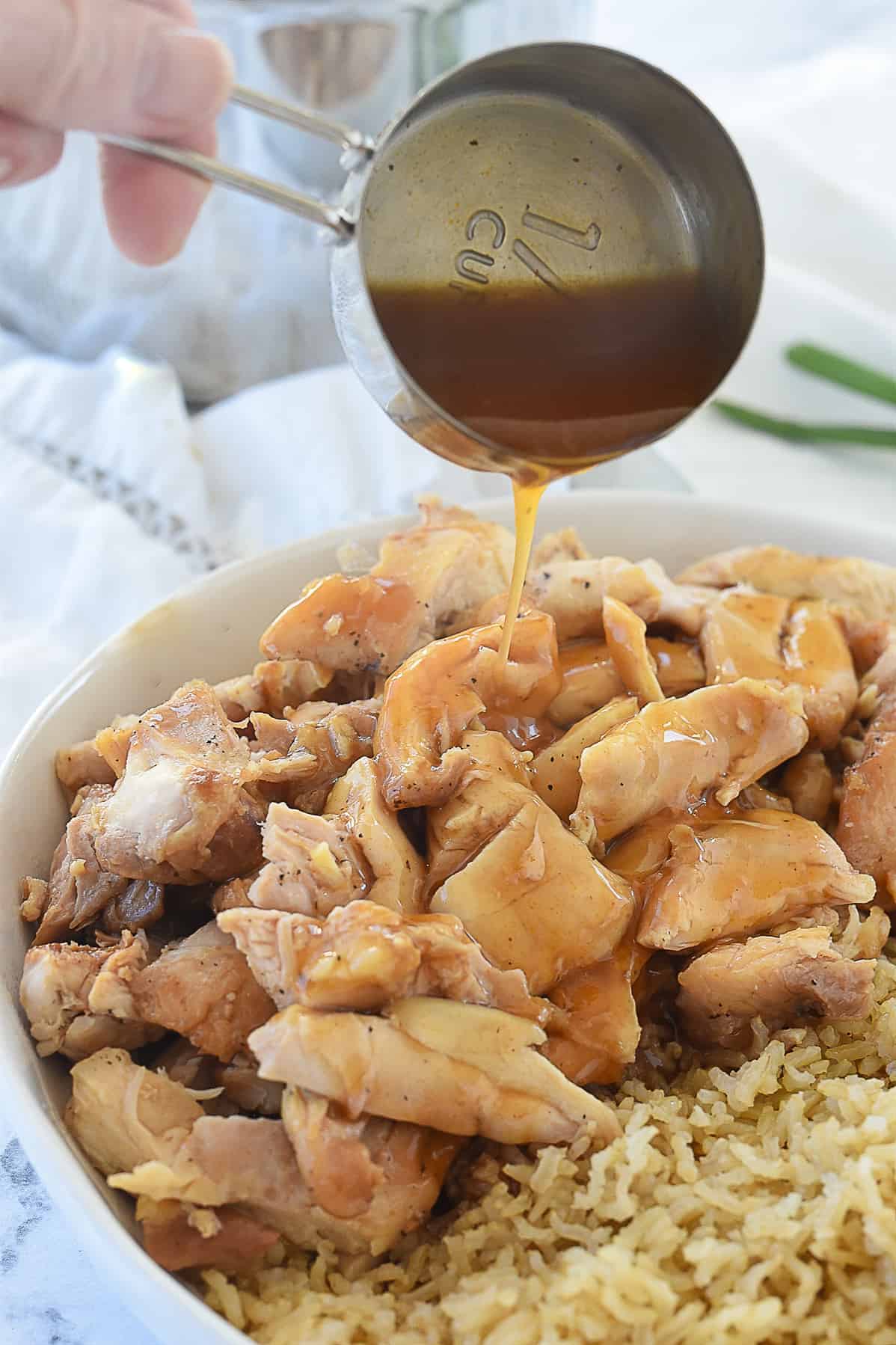 pouring sauce over chicken