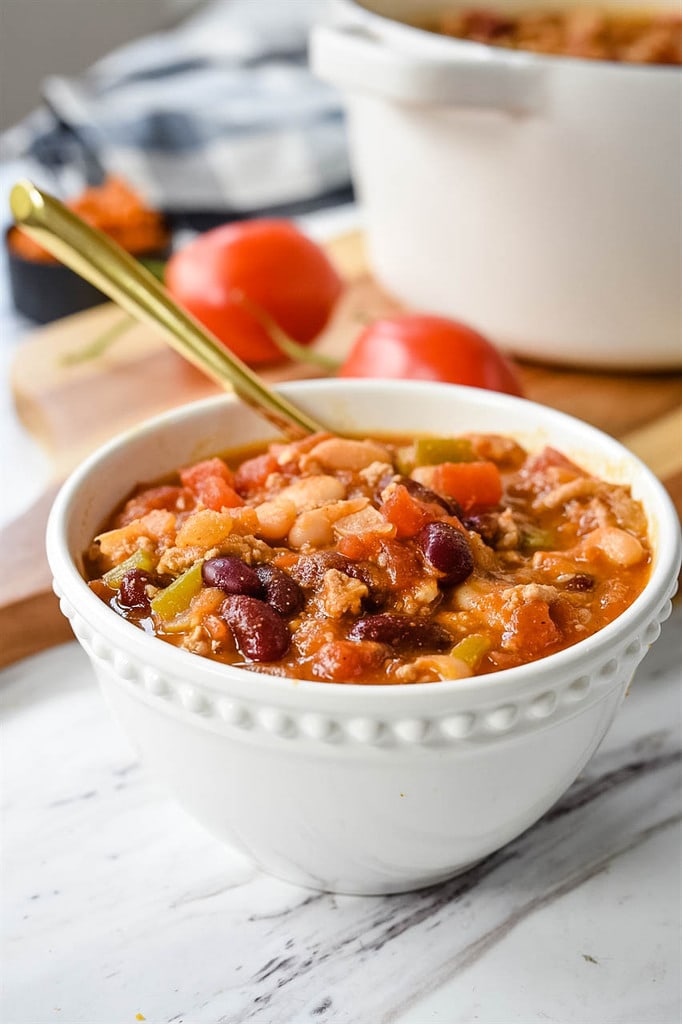 white bowl of Pumpkin Chili gold spoon