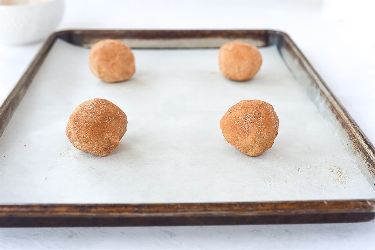 snickerdoodle cookie balls on baking sheet