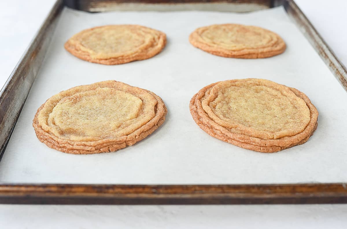 crispy snickerdoodle cookies on a baking sheet.