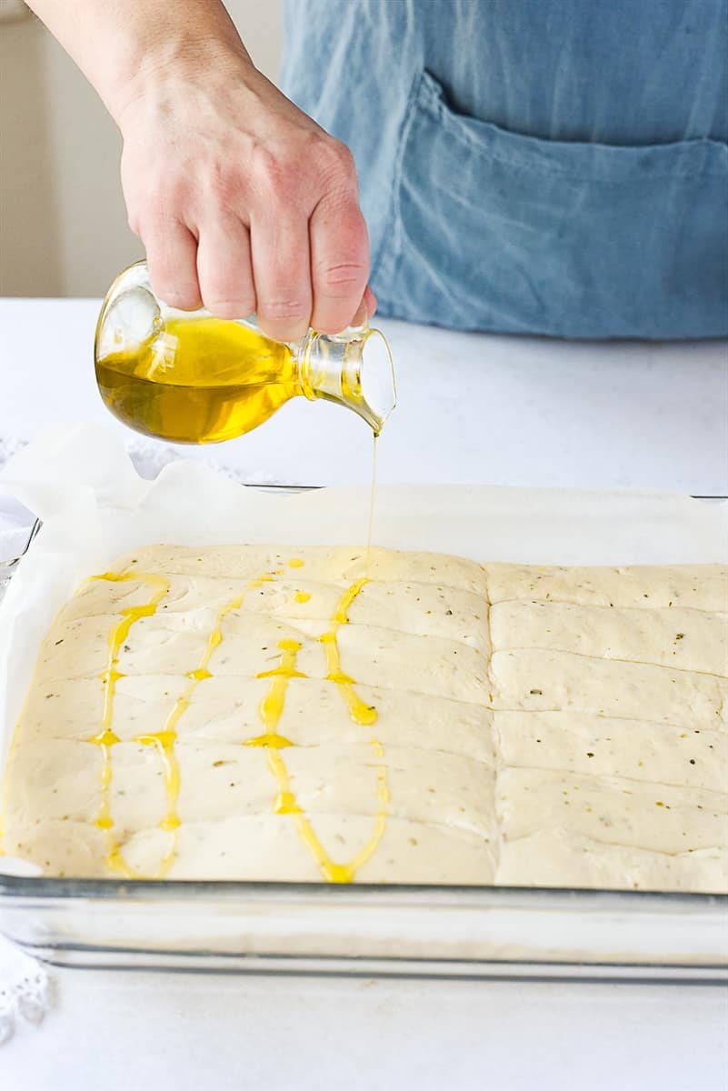 drizzling olive oil on breastick dough