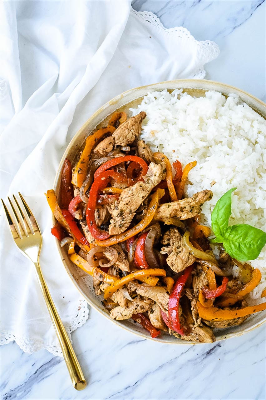 overhead shot of chicken and peppers in a bowl of rice