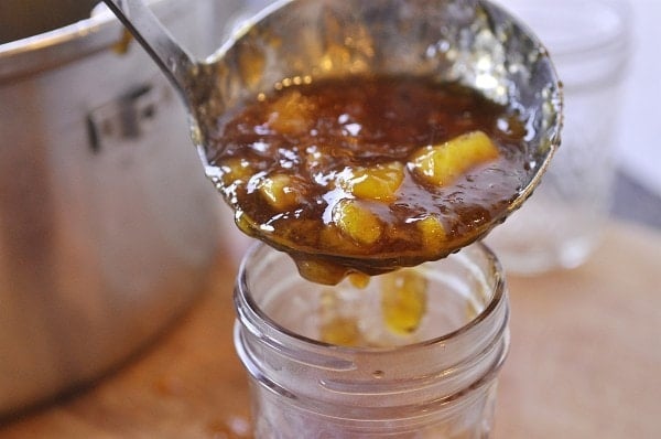ladeling peach jam into jars