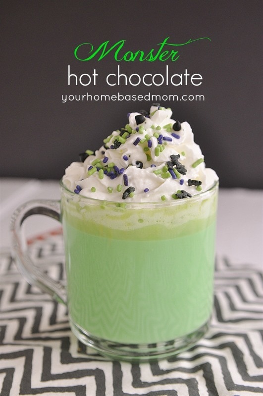 green hot chocolate topped with whipped cream and halloween sprinkles