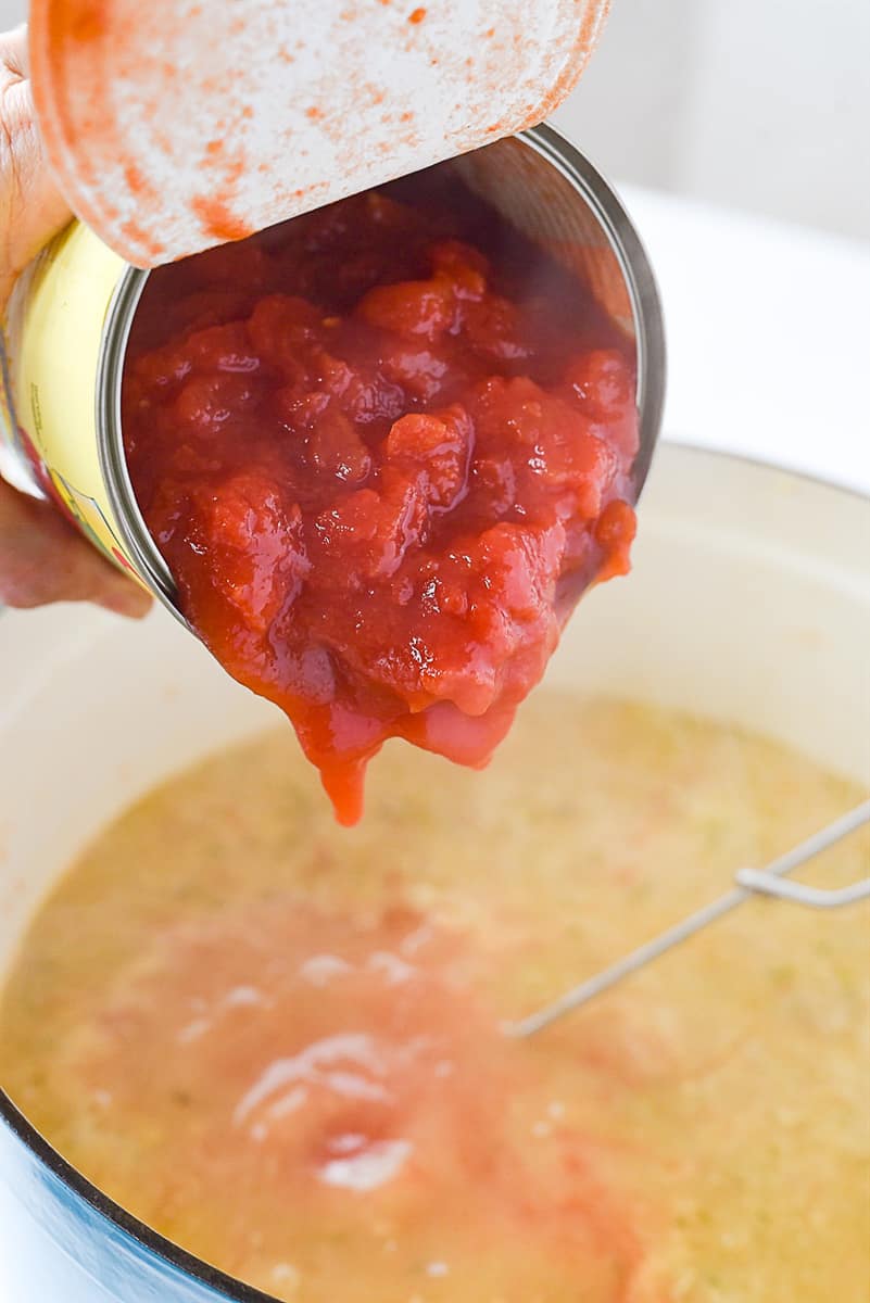 adding tomatoes to soup