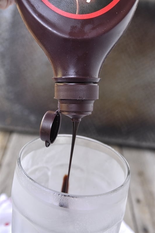 adding chocolate syrup to glass