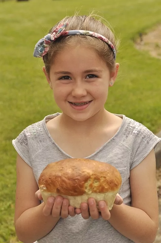 criança segurando um rolo de pão