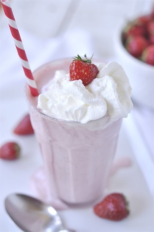 glass of strawberry milkshake with whipped cream on top