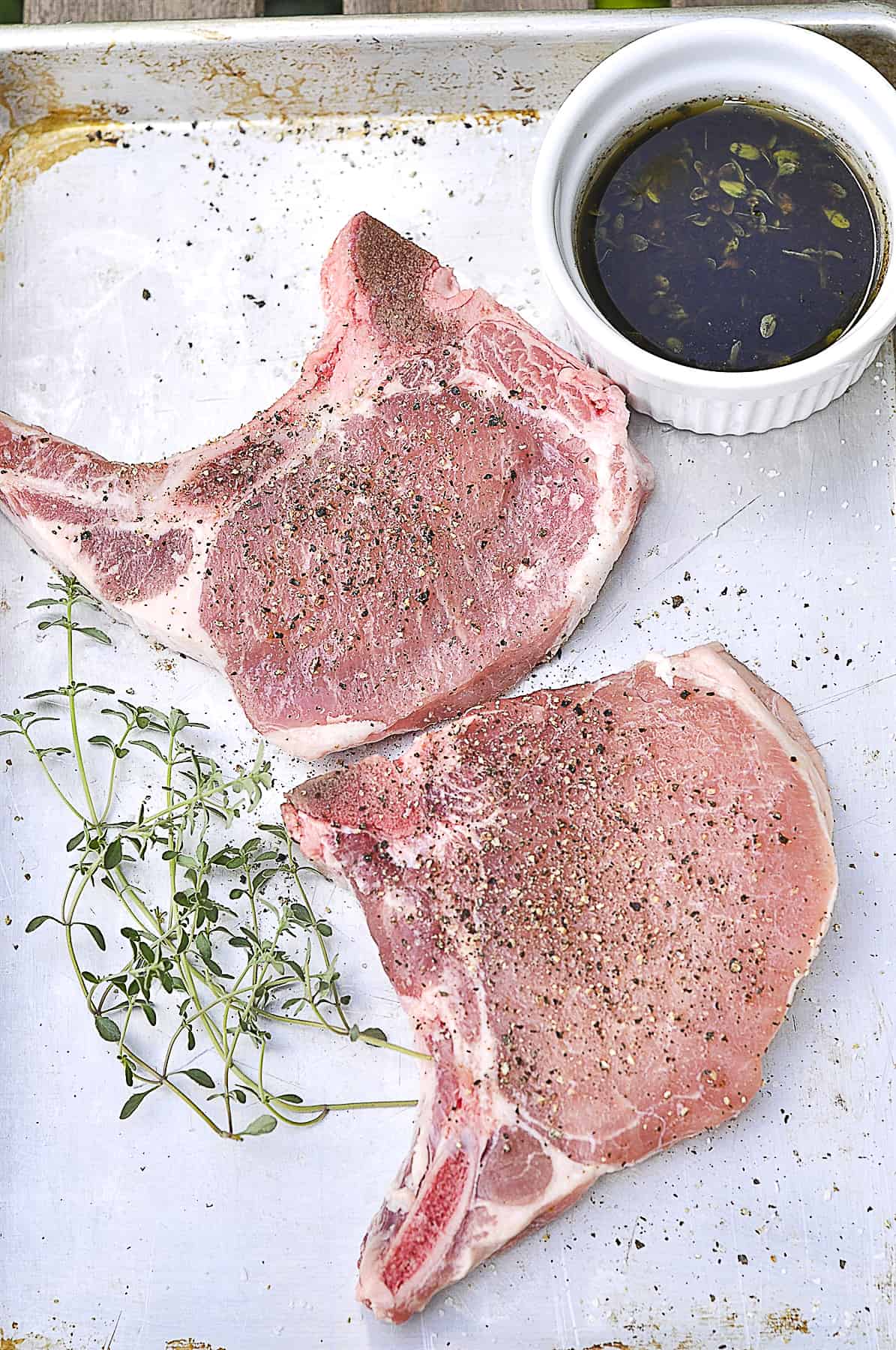 two uncooked pork chops on a plate