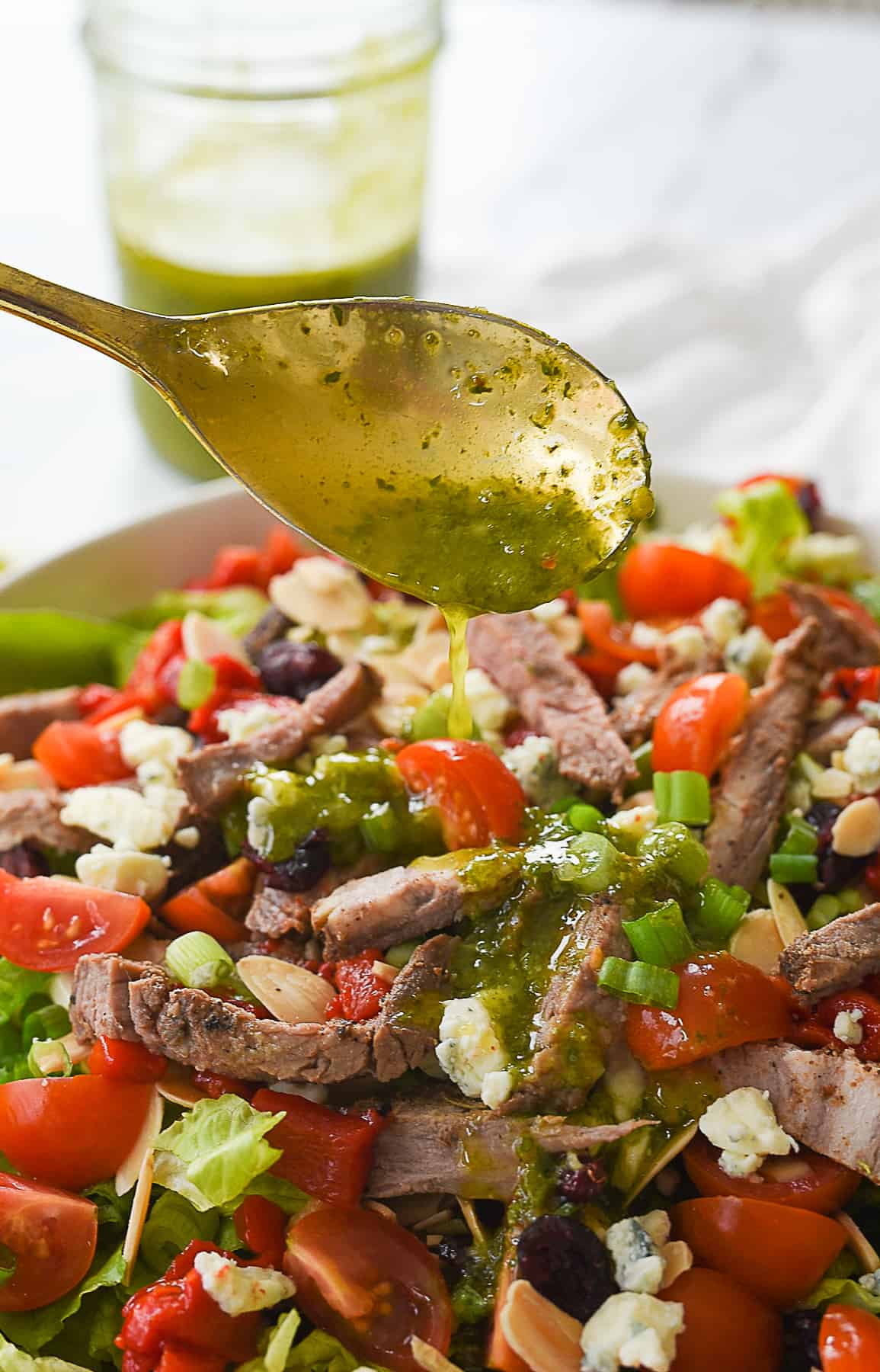 pouring dressing on steak salad