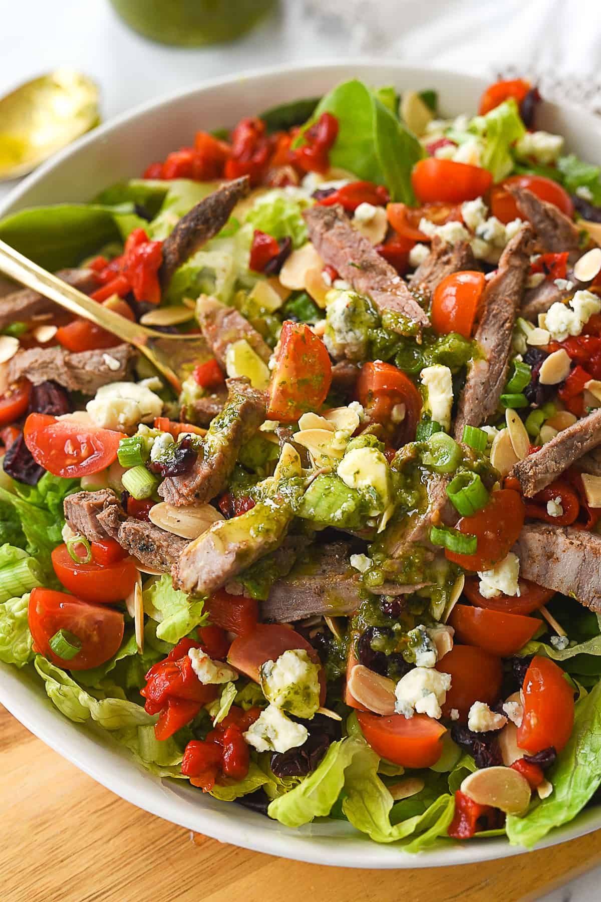 fork in steak salad in white bowl