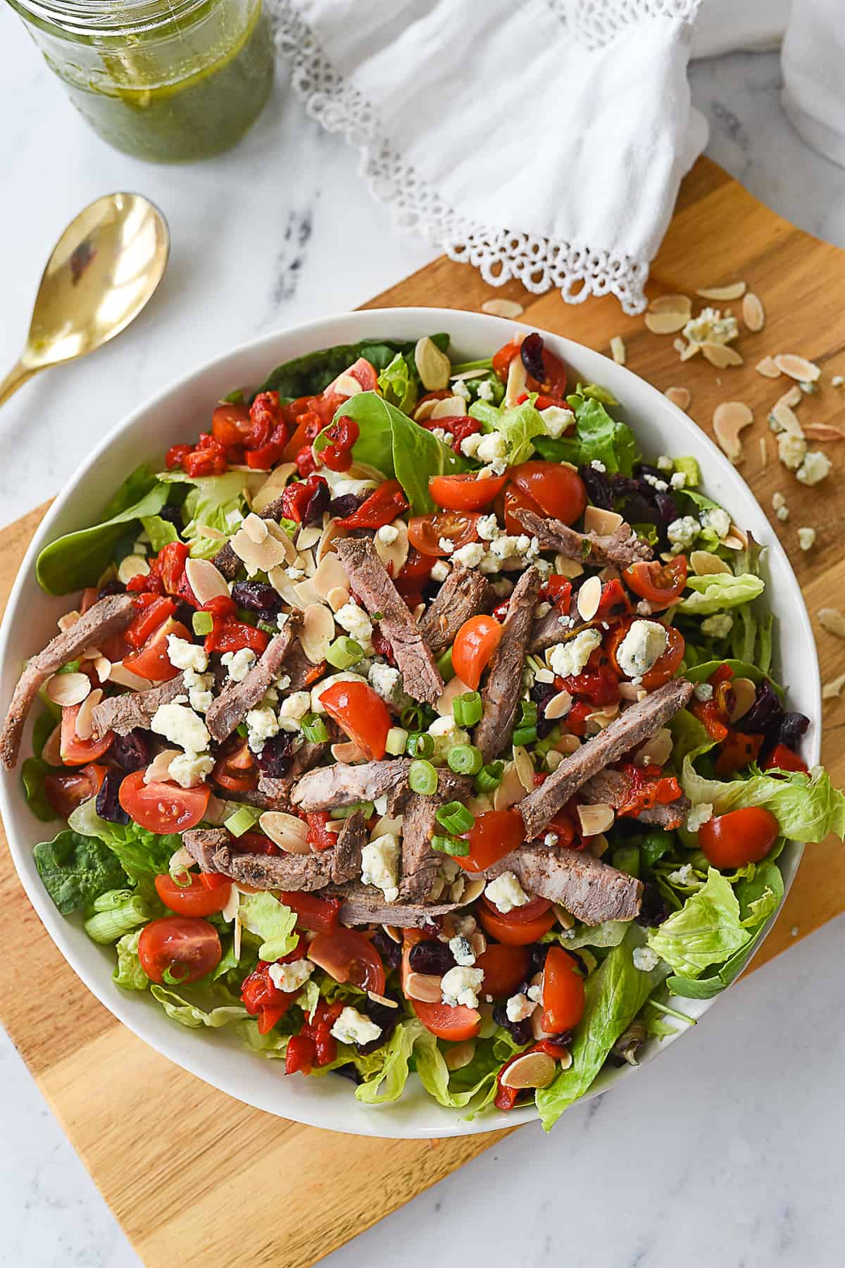 overhead shot of steak salad in a white bowl