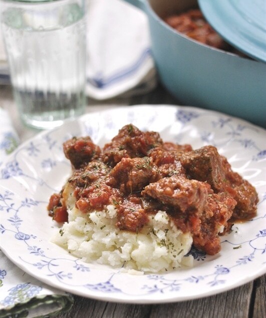 plate of swiss steak over mashed potatoes