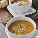 two bowls of pumpkin curry soup