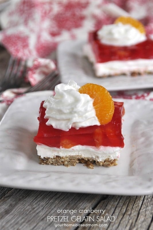 Orange Cranberry Pretzel Salad topped with whipped cream and mandarin orange